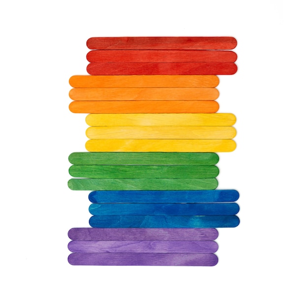 Bâtonnets de crème glacée en bois de couleur arc-en-ciel sur blanc concept abstrait multicolore lgbt