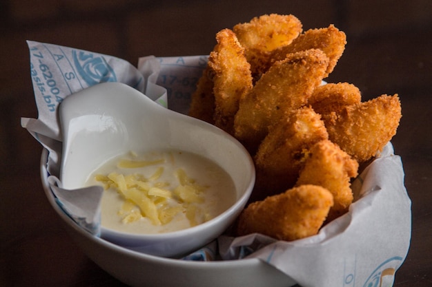 Bâtonnets CRISPY JOJOS avec trempette servis dans un plat isolé sur la vue latérale de la table