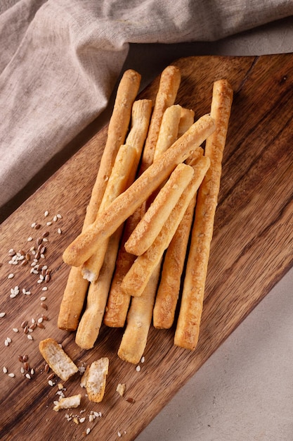 Bâtonnets de pain aux graines de sésame sur une vue de dessus de planche de bois