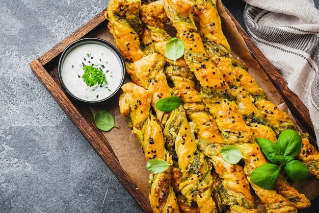 Bâtonnets de pain maison au fromage, sauce pesto et sésame noir