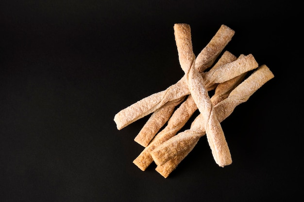 Bâtonnets de pâte feuilletée à la cannelle sur fond noir