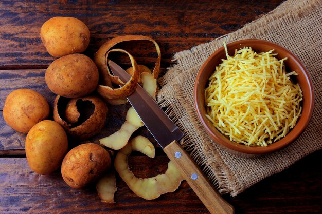 Bâtonnets de pomme de terre frites dans un bol en céramique sur une table en bois rustique