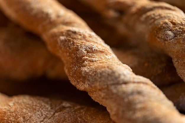 Bâtonnets de seigle croustillants saupoudrés de farine Rustique disposés sur un plateau recouvert d'un tissu Macro