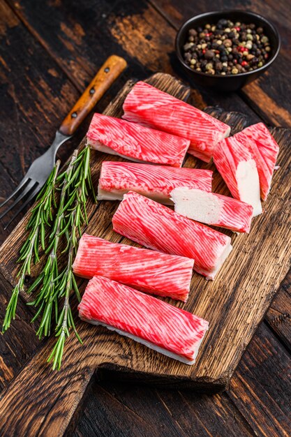 Bâtonnets de surimi de crabe en tranches sur une planche à découper en bois