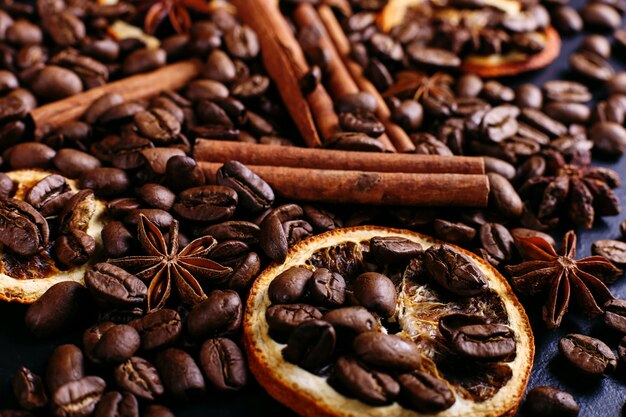 Bâtons de cannelle, anis étoilé, grains de café et orange séchée sur la table de la cuisine