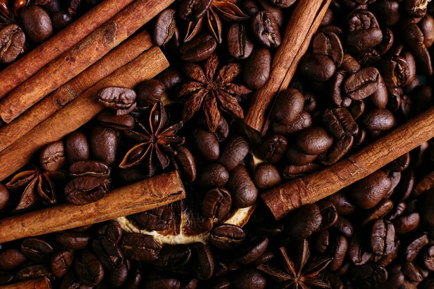 Bâtons de cannelle, anis étoilé, grains de café et orange séchée sur la table de la cuisine