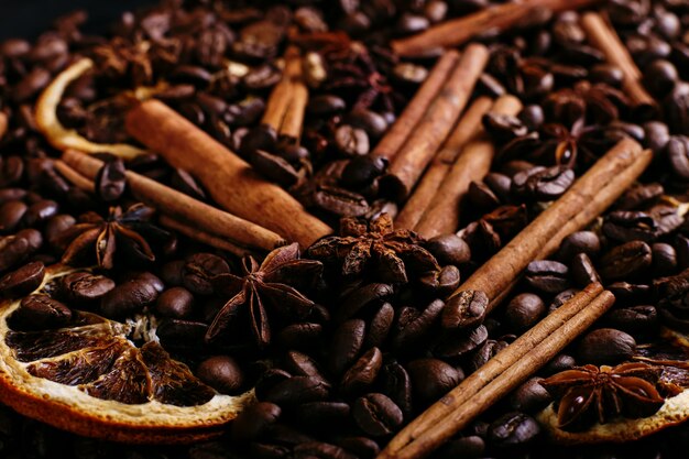 Bâtons de cannelle, anis étoilé, grains de café et orange séchée sur la table de la cuisine