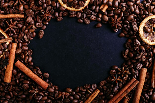 Bâtons de cannelle, anis étoilé, grains de café et orange séchée sur la table de la cuisine