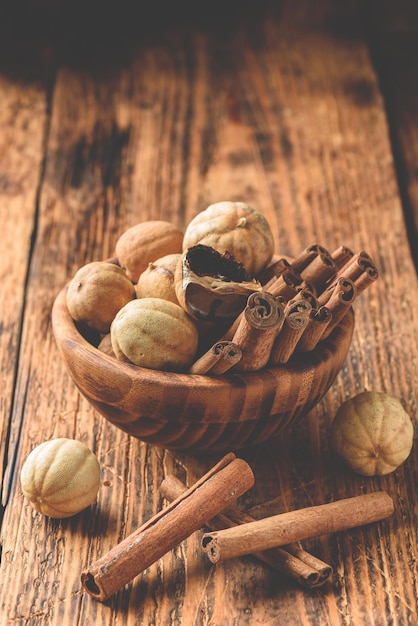 Bâtons de cannelle et citrons verts séchés dans un bol en bois