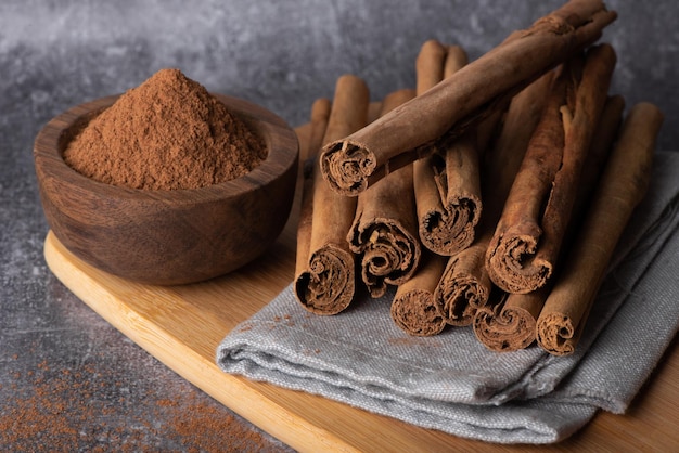 Bâtons de cannelle sur un fond en bois. Épices à la cannelle dans une cuillère et un bol. Cannelle de Ceylan.