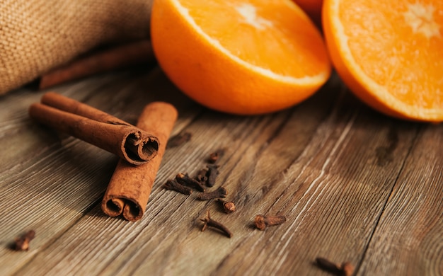 Bâtons de cannelle et moitiés d'oranges sur une vieille table en bois copie espace. Épices pour vin chaud