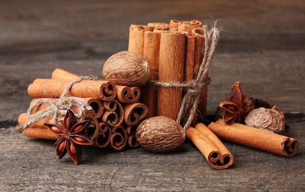 Bâtons de cannelle, muscade et anis sur table en bois