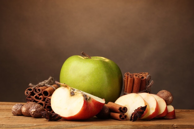 Bâtons de cannelle, pomme muscade et anis sur table en bois sur fond marron