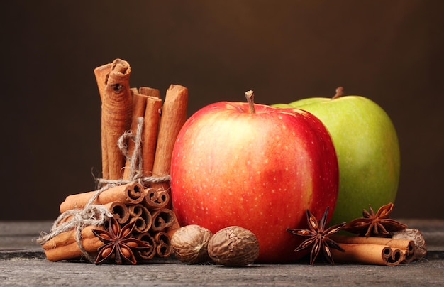 Bâtons de cannelle, pomme muscade et anis sur table en bois sur fond marron