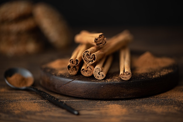 Bâtons et cannelle en poudre sur une planche