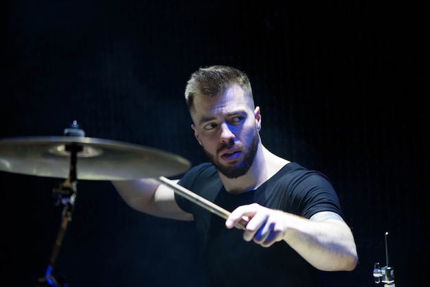 Batteur dans une casquette et des écouteurs joue de la batterie lors d&#39;un concert