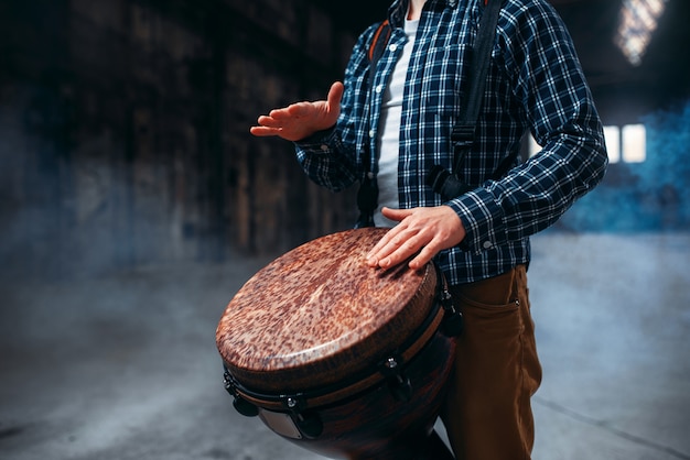 Batteur masculin jouant sur tambour en bois