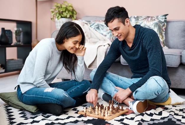 Battez le blues du verrouillage avec un jeu de société amusant Photo d'un jeune couple jouant aux échecs à la maison