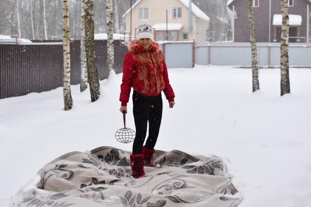 Battez le tapis de la poussière en hiver dans la neige. nettoyer les tapis de la maison avec de la neige. le tapis repose sur la neige blanche