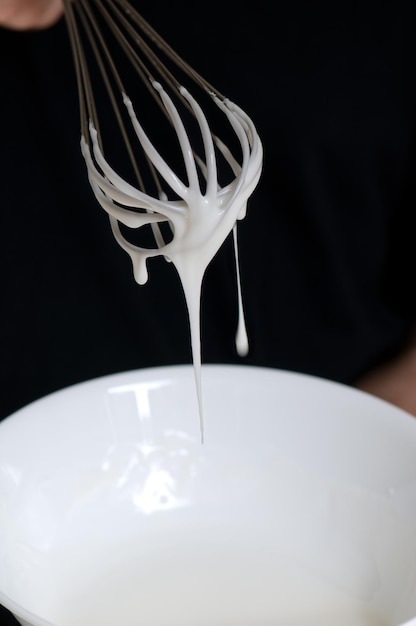 Battre avec du blanc d'œuf crémeux près du bol blanc