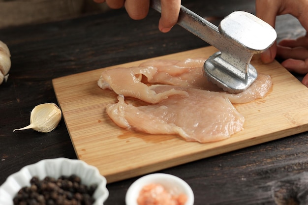 Battre le poulet avec un attendrisseur de viande