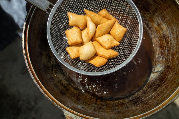 Photo les baursaks frais traditionnels kazakhs et d'asie centrale sont sortis d'un grand chaudron appétit traditionnel pour la fête de nauryz