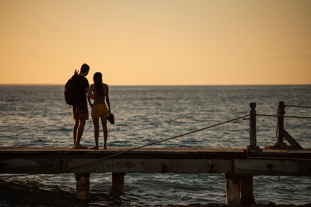 BAYAHIBE, RÉPUBLIQUE DOMINICAINE 13 DÉCEMBRE 2019 : Jeune couple amoureux sur la jetée de susnset