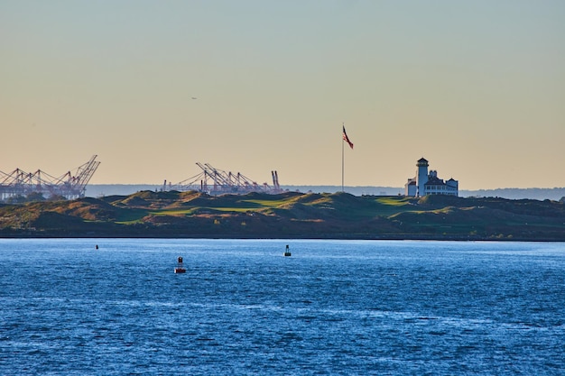 Photo bayonne golf country club à new york à partir des eaux avec des structures industrielles et drapeau américain