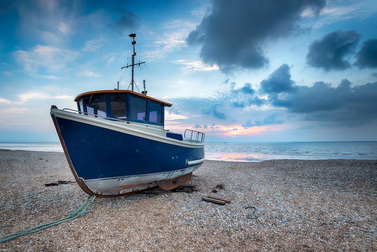 Photo bboat bleu sur une plage de galets