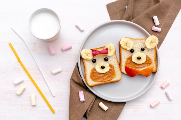 Beardog mignon drôle fait face à un sandwich au pain grillé avec du beurre d'arachide, de la banane, du lait de pomme, de la guimauve