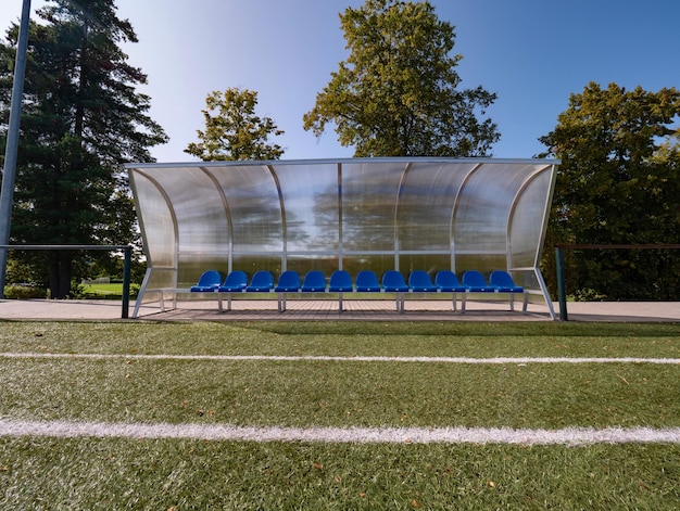 Photo beats sur les chaises de banc des joueurs du stade en plein air avec de la peinture bleue sous le toit transparent