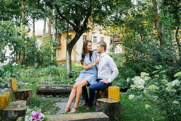 Photo beau amoureux couple heureux gars et fille assise sur un banc un jour d'été.