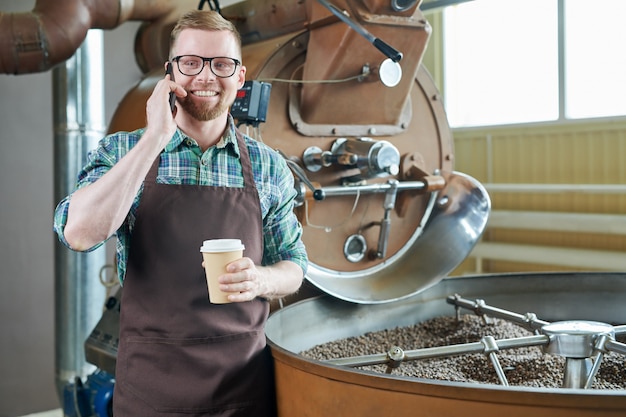 Beau barista parlant par téléphone