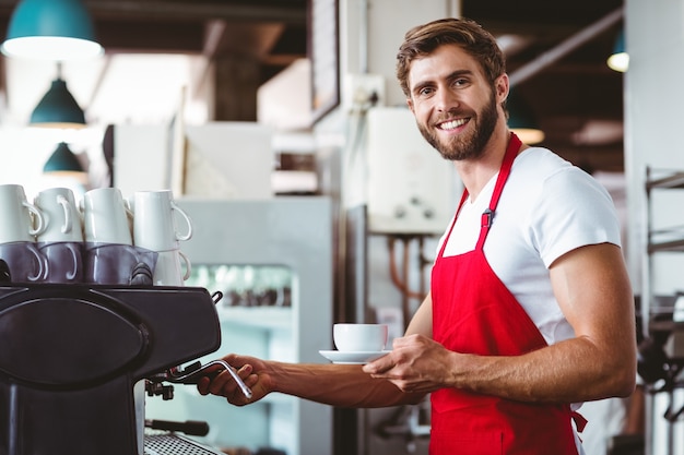 Beau barista prépare une tasse de café