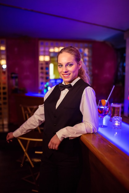 Beau barman se penchant au comptoir du bar