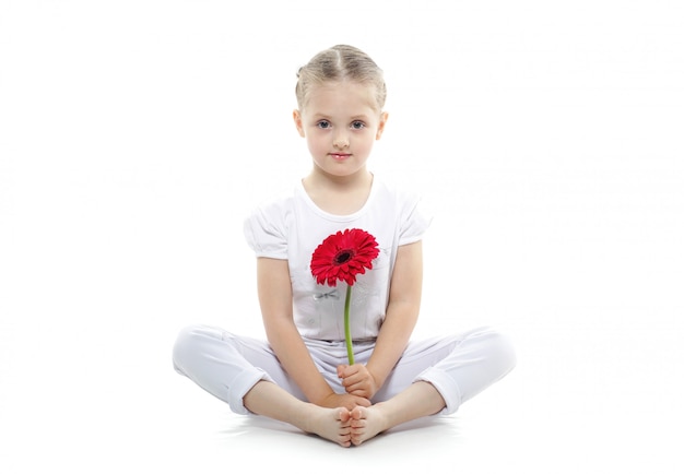 beau bébé avec gerbera fleur posant sur fond blanc