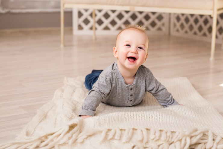 Photo beau bébé mignon souriant. rire bébé garçon allongé sur le ventre à la maison.