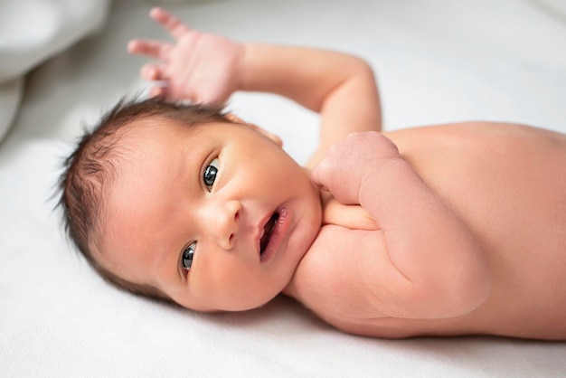 Photo beau bébé nouveau-né avec les yeux ouverts l'enfant a sept jours