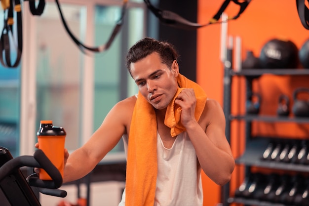 Beau bel homme prenant une pause dans l'entraînement