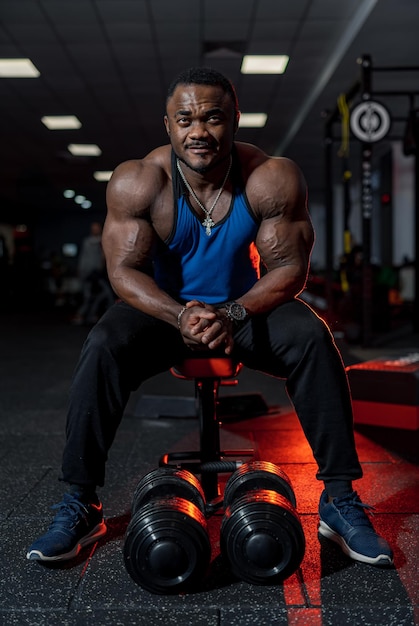 Beau bodybuilder musclé dans une salle de sport moderne. Homme de fitness fort avec un corps athlétique.