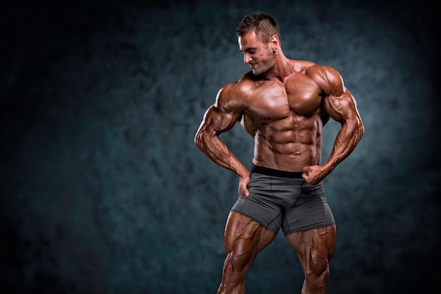 Beau bodybuilder musclé fléchissant les muscles