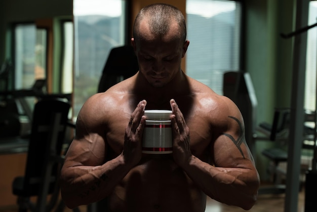 Photo beau bodybuilder musclé avec des pilules et de la drogue pour l'espace de copie