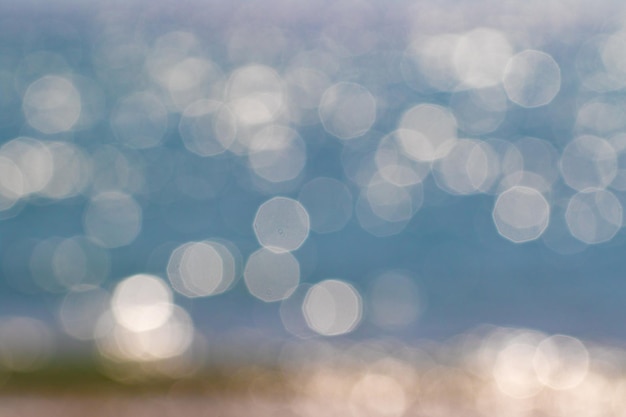 Un beau bokeh en bord de mer donne un arrière-plan atmosphérique de vacances d'été profond, un océan défocalisé avec des teintes bleues crée un motif de rêve et de la place pour la copie