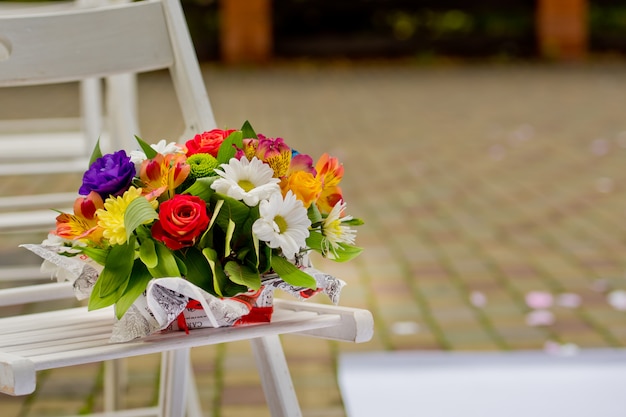 beau bouquet cadeau dans un vase en bois sur un banc en bois.