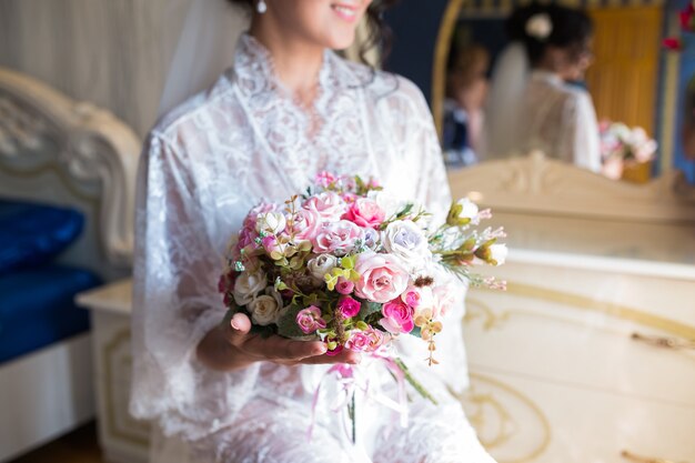 Beau bouquet coloré de mariage avec différentes fleurs dans les mains de la mariée. Bouquet de mariée d'été