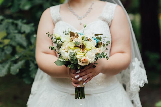 Beau bouquet dans les mains de la mariée très grasse