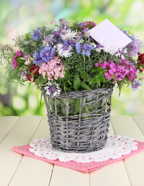 Beau bouquet dans un panier sur une table en bois sur fond naturel