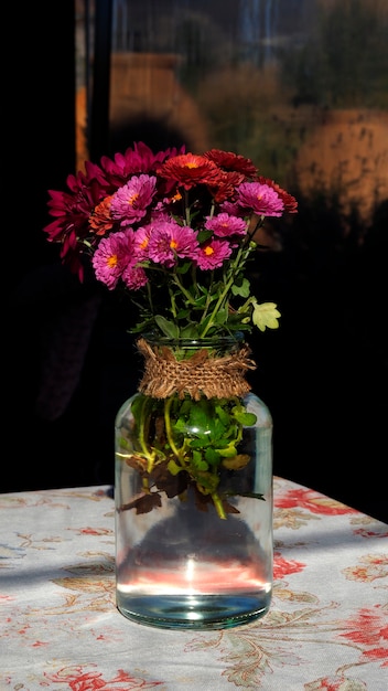 Beau bouquet de fleurs aux couleurs vives dans un bocal sur la table. Intérieur de style provençal avec bouquet