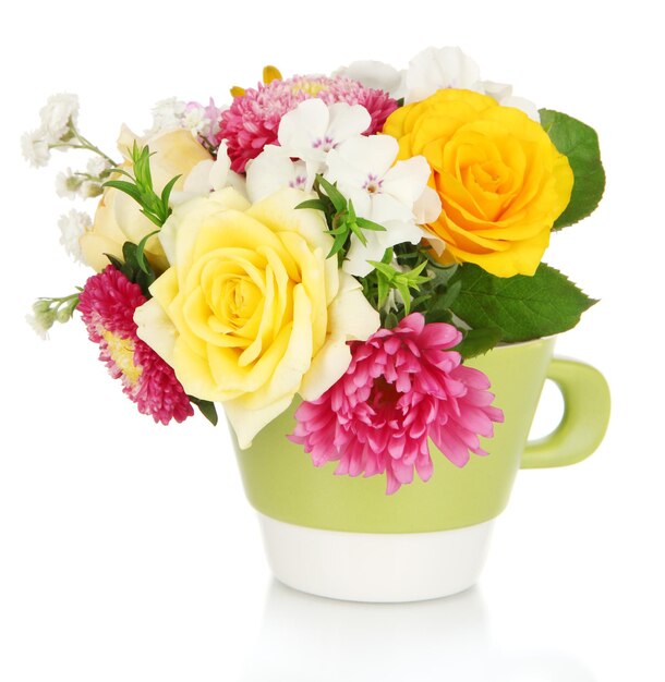 Beau bouquet de fleurs aux couleurs vives dans une tasse de couleur isolée sur blanc