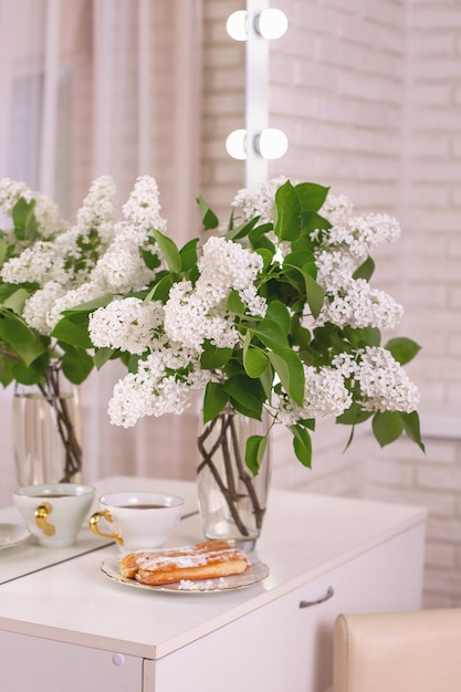 Beau bouquet de fleurs blanches dans un vase sur une table dans un miroir de salon de beauté